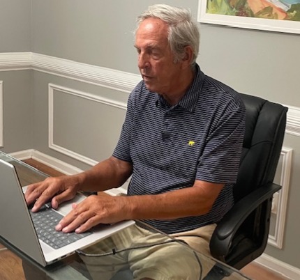 Harris Brown sitting at his desk typing on his laptop